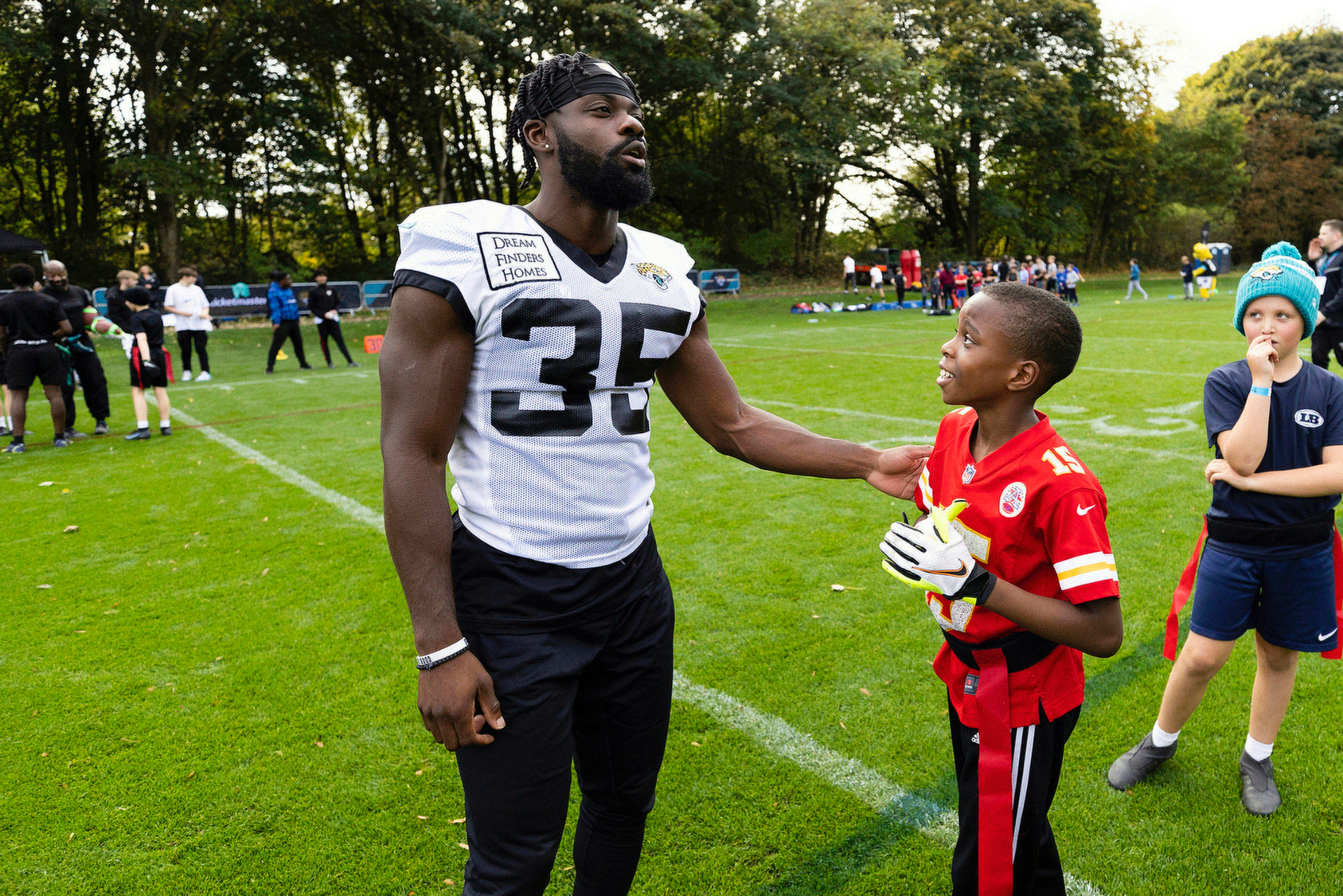 Talking with a young athlete at a youth football camp